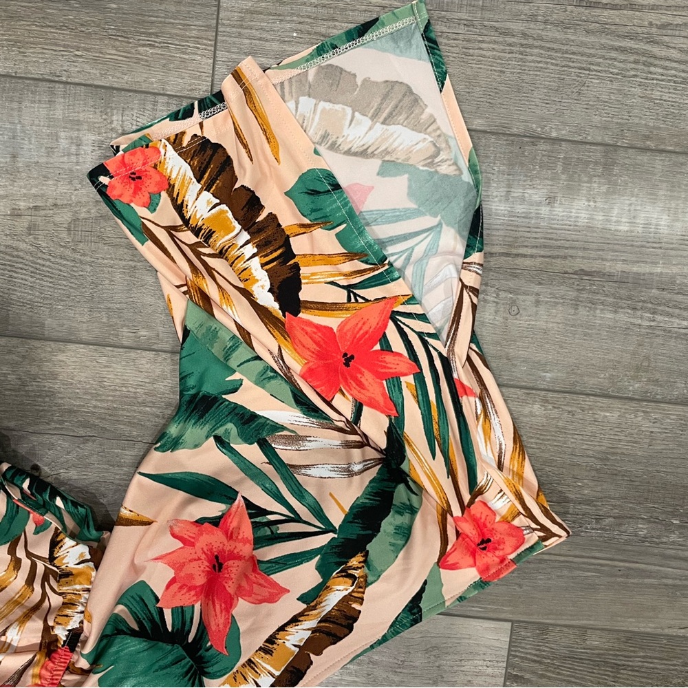 Floral, silky romper with slit in sleeves, back has tie. Never worn. No tags
